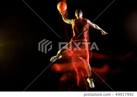 Young basketball player against dark background Young basketball player against dark background 49917992