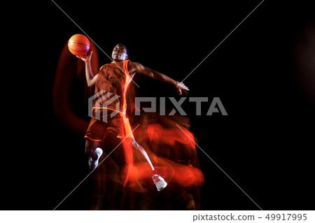 Young basketball player against dark background Young basketball player against dark background 49917995