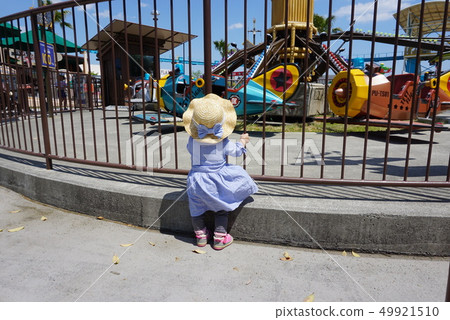 Girl watching the ride at the amusement park Girl watching the ride at the amusement park 49921510