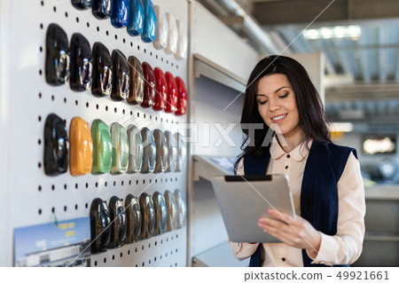 Professional salesperson help to chose color for a car in dealership center Professional salesperson help to chose color for a car in dealership center 49921661