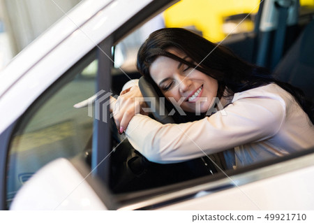 Happy customer woman buying a new car in dealeship center Happy customer woman buying a new car in dealeship center 49921710