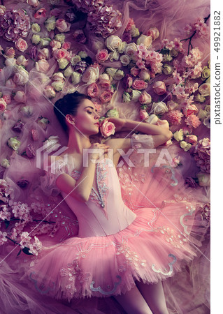 Young woman in pink ballet tutu surrounded by flowers Young woman in pink ballet tutu surrounded by flowers 49921882