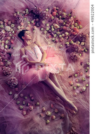 Young woman in pink ballet tutu surrounded by flowers 49922004