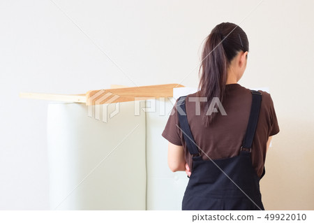 A woman reading a manual to assemble a couch A woman reading a manual to assemble a couch 49922010