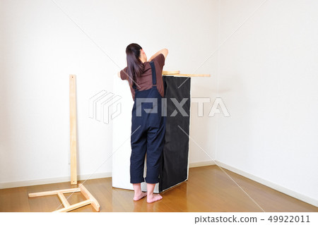 Woman assembling and disassembling a sofa Woman assembling and disassembling a sofa 49922011