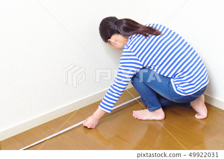 DIY A woman measuring the size of a room 49922031