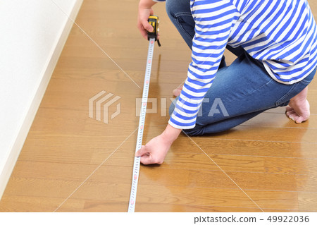 DIY A woman measuring the size of a room 49922036