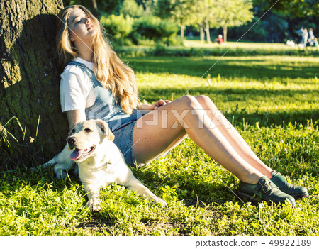 young attractive blond woman playing with her dog in green park at summer, lifestyle people concept young attractive blond woman playing with her dog in green park at summer, lifestyle people concept 49922189