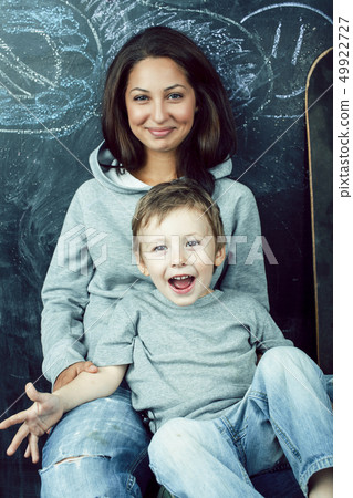 young hipster teenage girl sitting with her little brother in classroom multinational, lifestyle young hipster teenage girl sitting with her little brother in classroom multinational, lifestyle 49922727