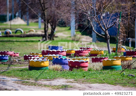 Colorful flowerbeds made of several old car tires 49923271