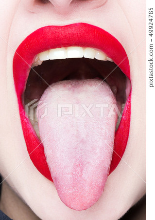 The girl shows her tongue. Red lips. Face close-up The girl shows her tongue. Red lips. Face close-up 49924785