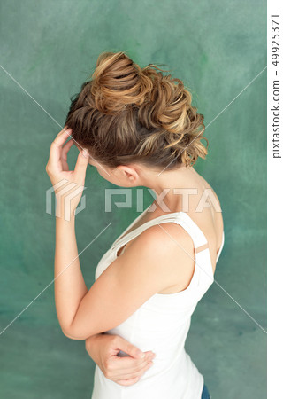 Fashion studio portrait of a beautiful brunette lady with a chic hairstyle in erokez style in a Fashion studio portrait of a beautiful brunette lady with a chic hairstyle in erokez style in a 49925371