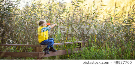 Little boy with binoculars sitting on a wooden 49927760