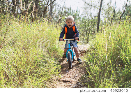 Toddler riding a balance bike Toddler riding a balance bike 49928040