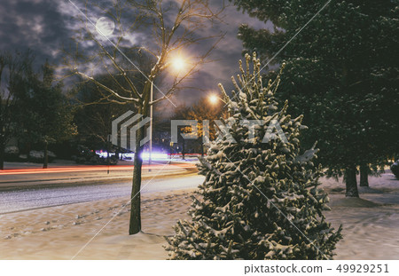 A car headlights on a snowy night road in winter A car headlights on a snowy night road in winter 49929251