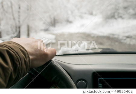 Man's hand on the steering wheel of a car Man's hand on the steering wheel of a car 49935402