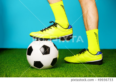 Soccer player with ball on the green grass. 49936733