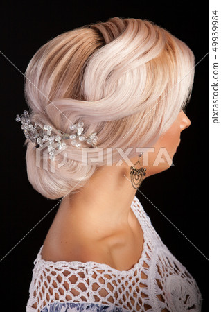 Woman with long blond hair and stylish coiffure in studio background 49939984