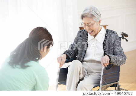 Elderly people and helper in wheelchairs Elderly people and helper in wheelchairs 49940793