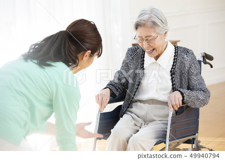 Elderly people and helper in wheelchairs Elderly people and helper in wheelchairs 49940794