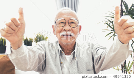 Asian senior making a thumb up gesture and smiling Asian senior making a thumb up gesture and smiling 49941330
