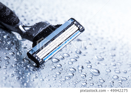 Razor close-up with water drops on a gray background. 49942275