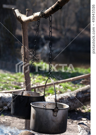 Two sooty old cauldrons on bonfire at forest Two sooty old cauldrons on bonfire at forest 49943586