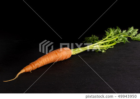 Fresh orange carrot on grey stone Fresh orange carrot on grey stone 49943950