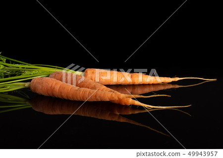 Fresh orange carrot isolated on black glass Fresh orange carrot isolated on black glass 49943957