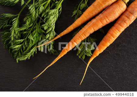 Fresh orange carrot on grey stone Fresh orange carrot on grey stone 49944018
