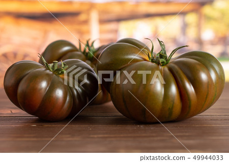 Fresh dark tomato primora with cart Fresh dark tomato primora with cart 49944033