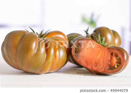 Fresh dark tomato primora with red tulips Fresh dark tomato primora with red tulips 49944079
