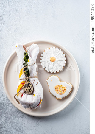 Table setting for the holiday of Easter. The photo shows white dishes, serving mat, Easter egg in a 49944358