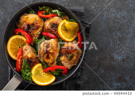 Pieces of chicken baked with oranges and red pepper. 49944410