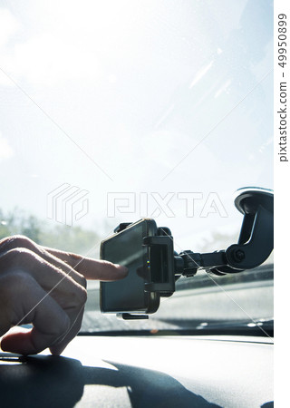 young man using a smpartphone as a GPS in a car 49950899