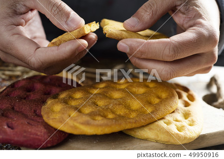 man splitting a piece of an italian focaccia. 49950916