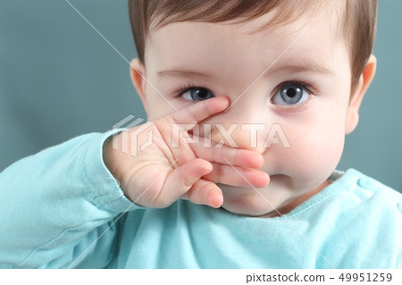 Close up of a baby girl looking at camera with a Close up of a baby girl looking at camera with a 49951259