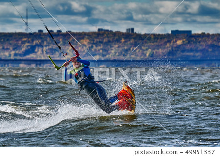 A male kiter slides on the surface of the water. 49951337