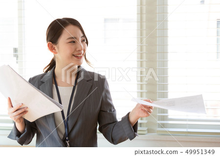 Businesswoman handing over documents 49951349