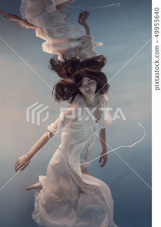 The girl in the white dress swims under water The girl in the white dress swims under water 49955640