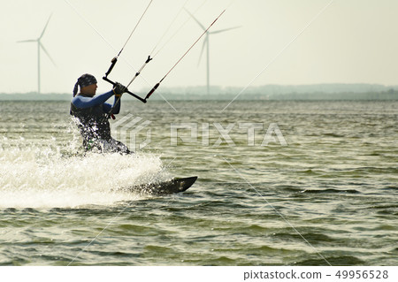 Kitesurfing Kiteboarding action photos man among waves quickly goes Kitesurfing Kiteboarding action photos man among waves quickly goes 49956528