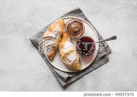 Freshly baked croissants with berry jam on gray. 49957378