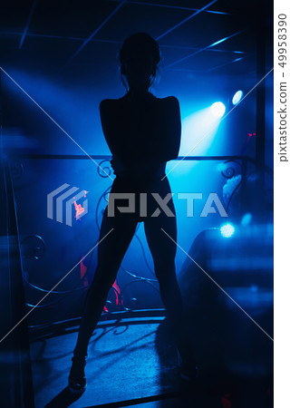 go-go dancer posing on stage in a nightclub go-go dancer posing on stage in a nightclub 49958390