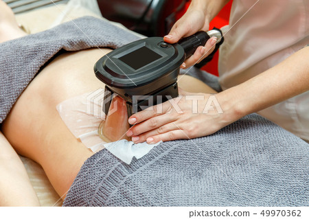 Beauty therapist applying cryolipolysis treatment. 49970362