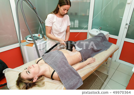 Beauty therapist applying cryolipolysis treatment. Beauty therapist applying cryolipolysis treatment. 49970364