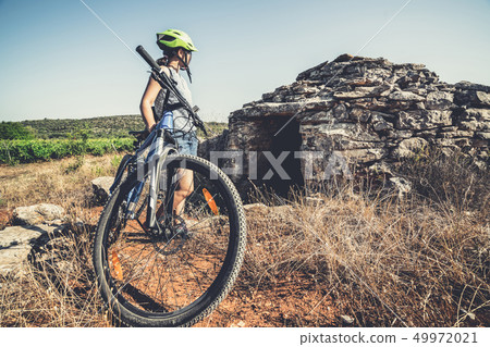 Woman traveler ride bicycle in Hvar, Croatia. Woman traveler ride bicycle in Hvar, Croatia. 49972021