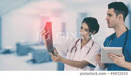 Doctors discussing and looking at x ray film. 49972033
