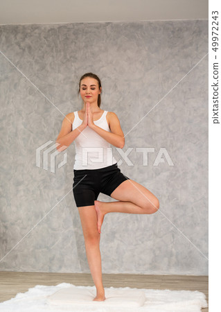 Young woman yoga on carpet at home living room. 49972243