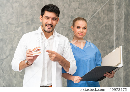 Dentist and nurse working in dental office. 49972375