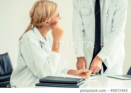 Female doctor at hospital talking to her partner. 49972465